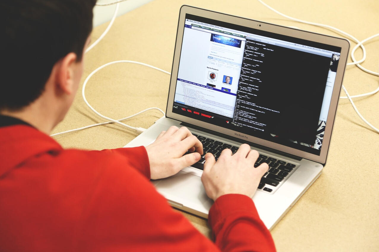 a boy typing in a laptop